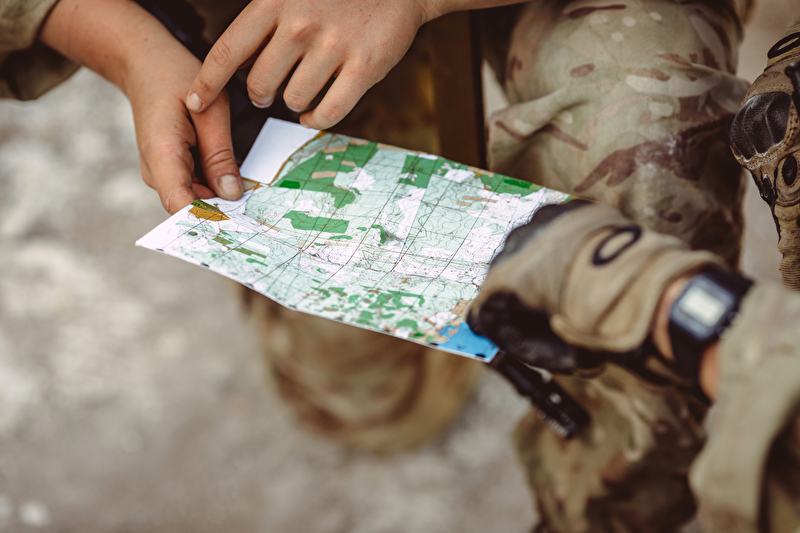 Das Bild zeigt zwei Soldaten die eine Landkarte studieren